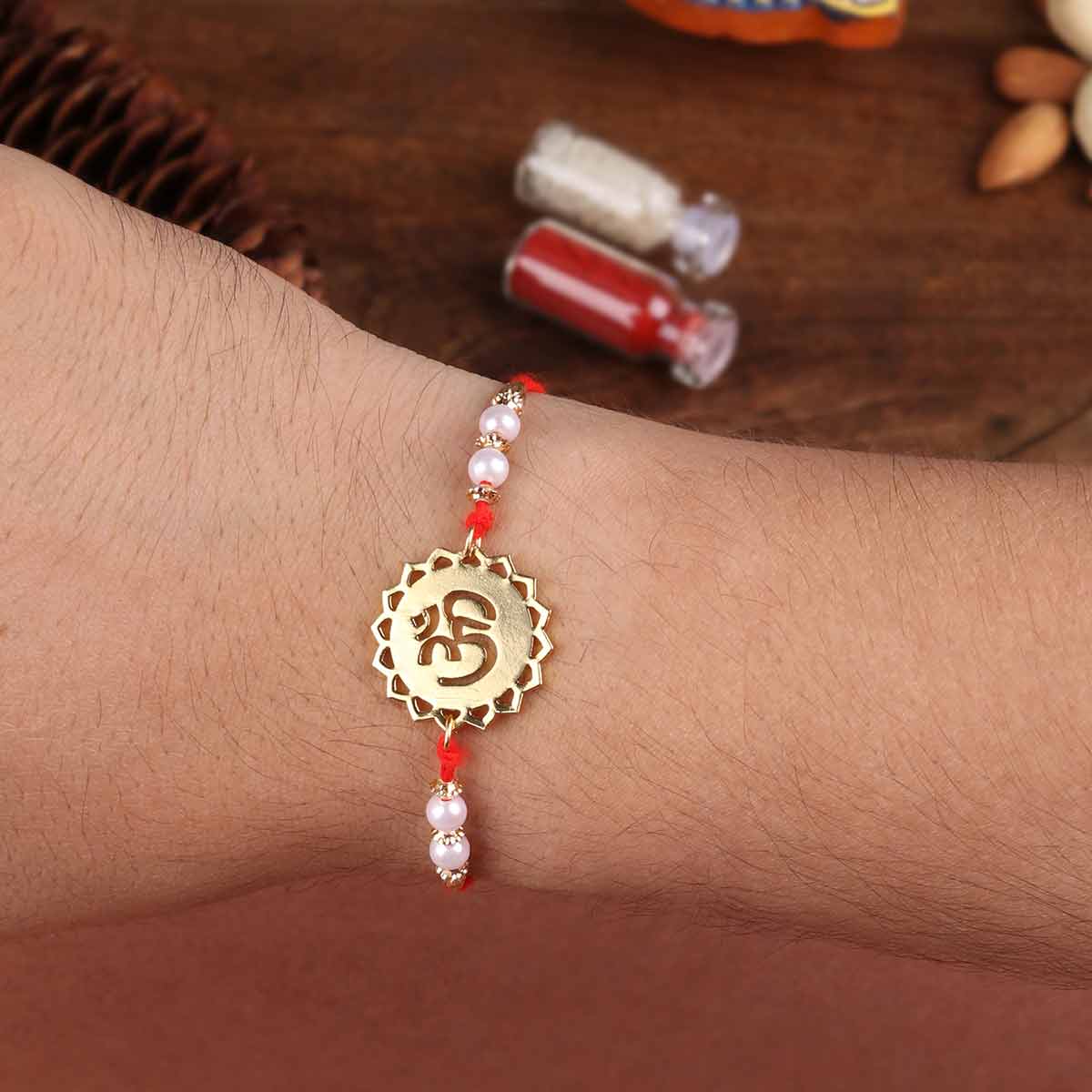 Divine Om Metal Rakhi With Pearl Beads